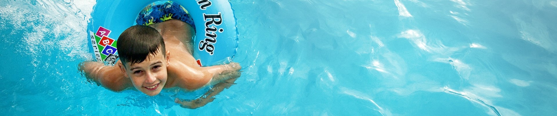 child swimming with a tube in the pool